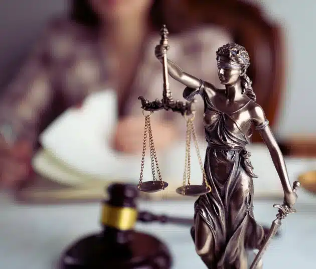 Lady justice on the desk of a car accident lawyer who can help answer your question: "Can I sue if I get hit by a FedEx driver in Florida?"